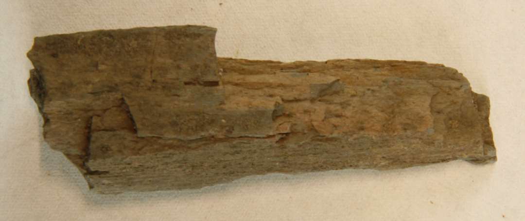 Fragment af hvæssesten af fys-grå skifer. Mål: 5,5x2x2 cm. 
