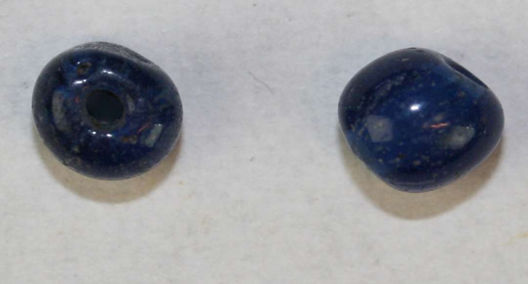 To ringformede, afskårne, hele, halvgennemsigtige blå perler. Diameter: 4 mm.
