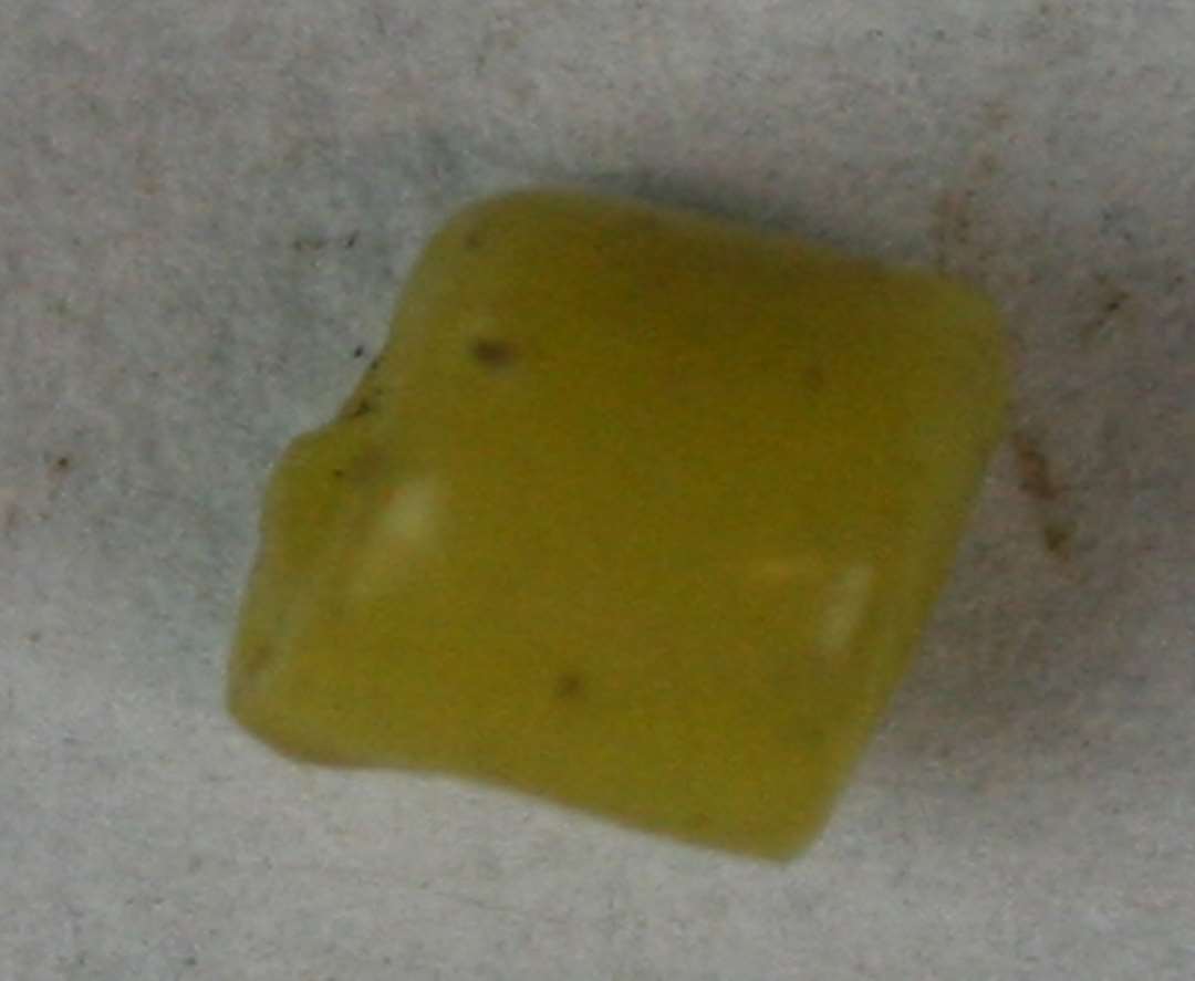 Cylindrisk, afskåret, hel, uigennemsigtig gul perle. Længde: 0,4 mm.