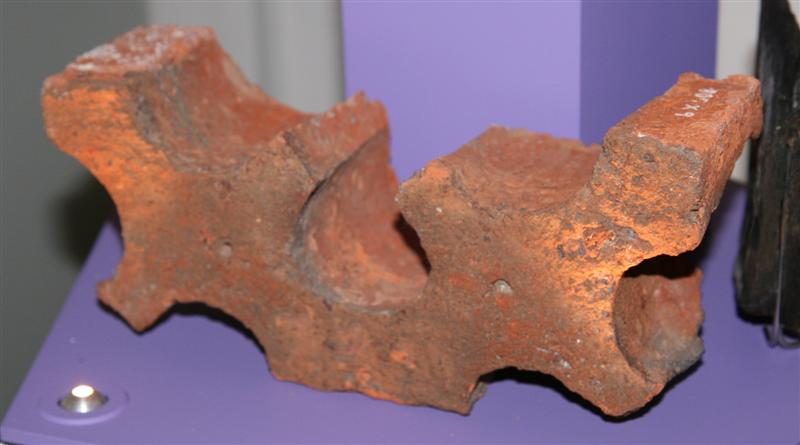 En formsten, som udgør den ene halvpart af sten parrene i de udsmykkede kløverbladsfriser, der findes på klosterfløjens gårdside.