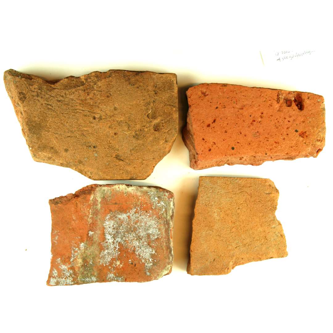 4 fragmenter af rødbrændt gulvfliser. uden spor af glasur. Alle nedslidte. Tykkelse: 2,3 - 2,8 cm.