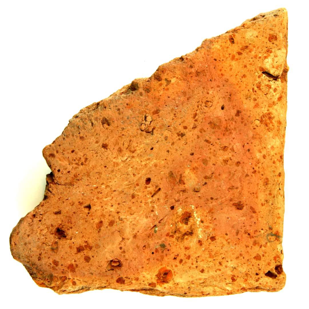 Fragment af rødbrændt uglaseret gulvflise. Nedslidt. Mål: 15,8 x 15,5 cm. Tykkelse: 3,5 cm.