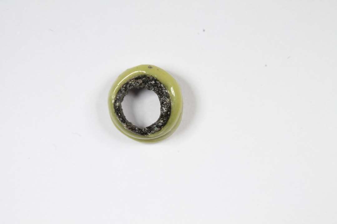 Fragment af hvepseperle, uigennemsigtig, sort med gult bånd. diameter: 0,8 cm.