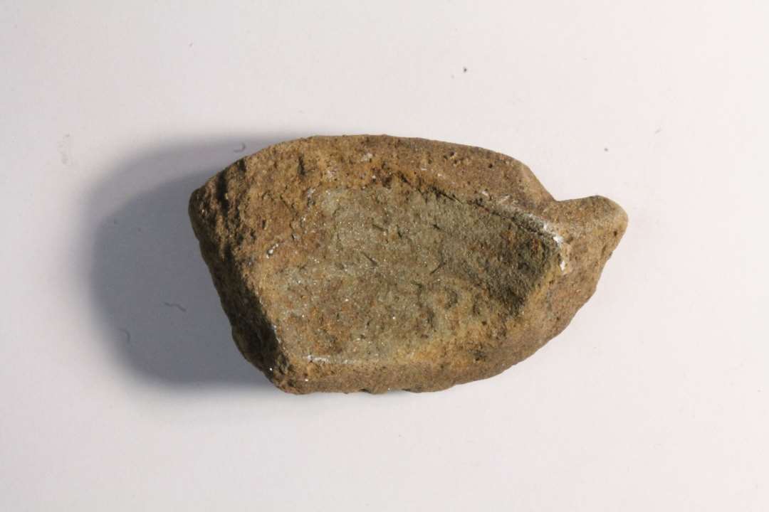 Fragment af støbeform til skålformet spænde. Styrehak. Største mål: 4,6 cm.