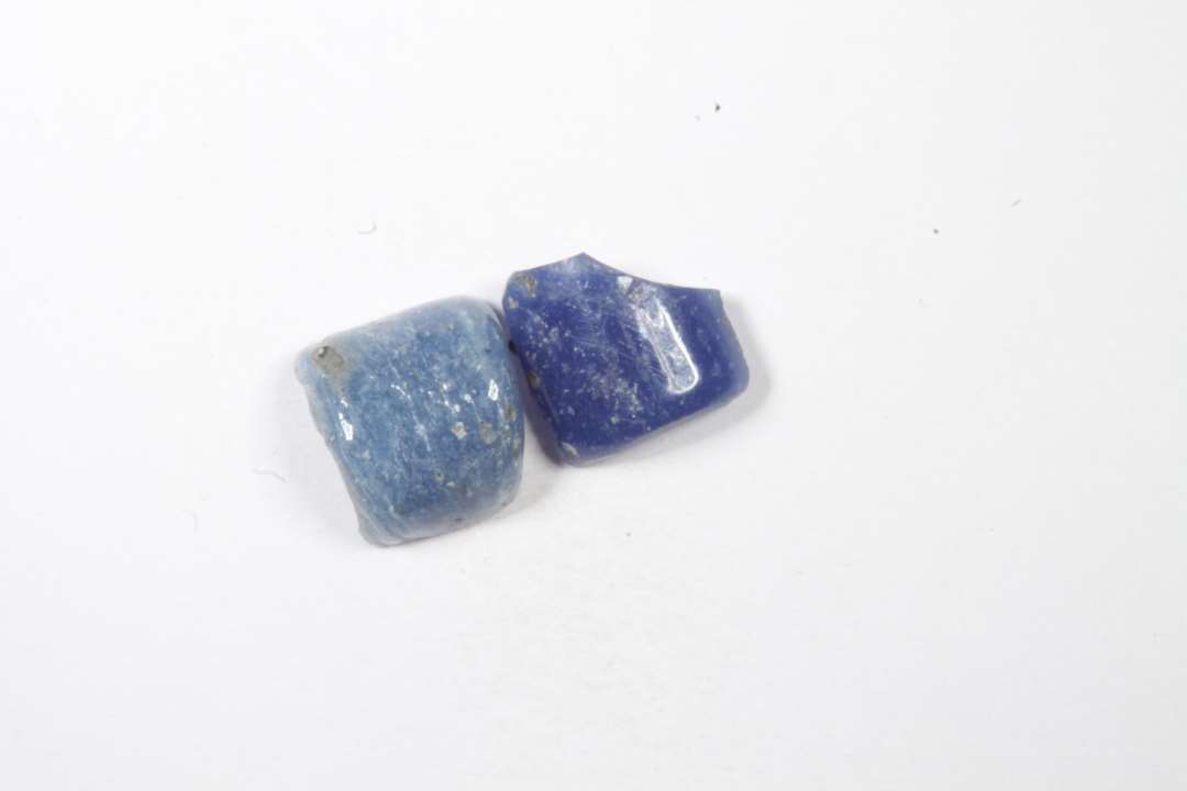 2 fragmenter af cylindriske, uigennemsigtige blå glasperler