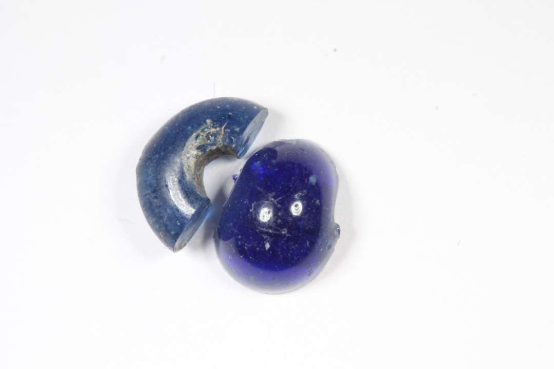 To halve, ringformede, gennemsigtige,  blå glasperler. diameter: 1 og 1,1 cm.