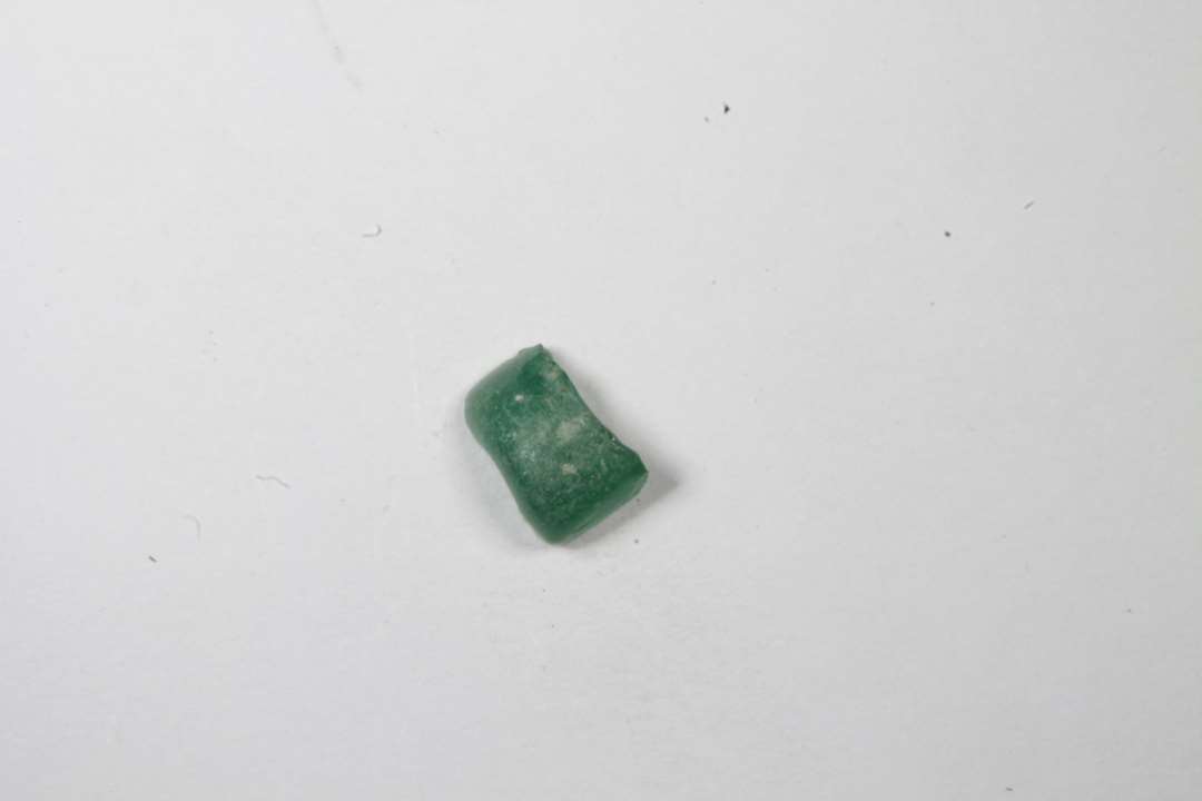 Fragment af cylindrisk, halvgennemsigtig grøn glasperle