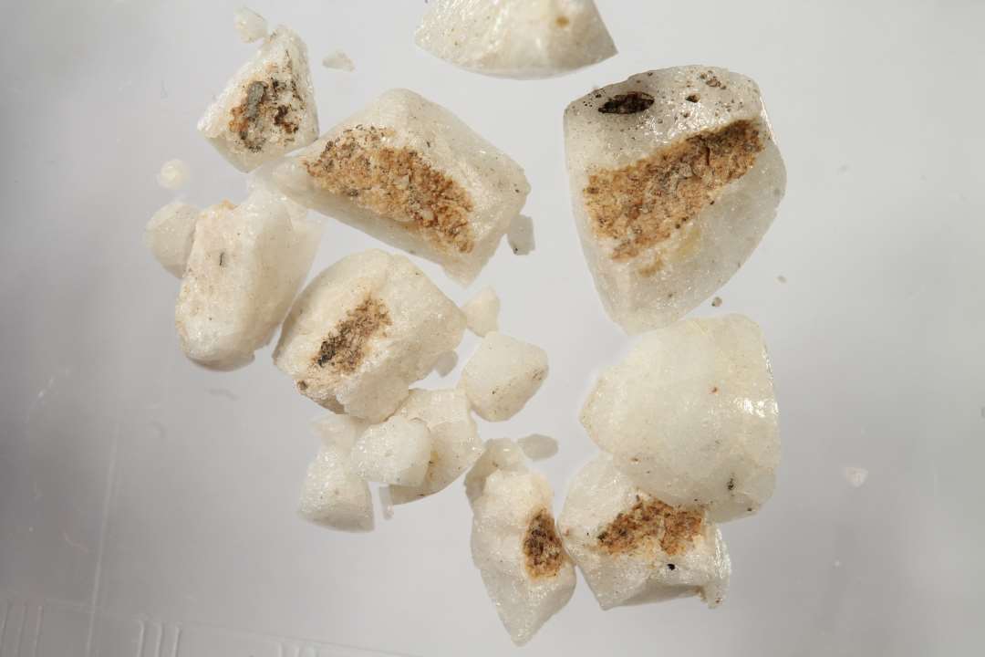 Mange små fragmenter af cylindrisk, muligvis samme uigennemsigtige, hvidgrå glasperle