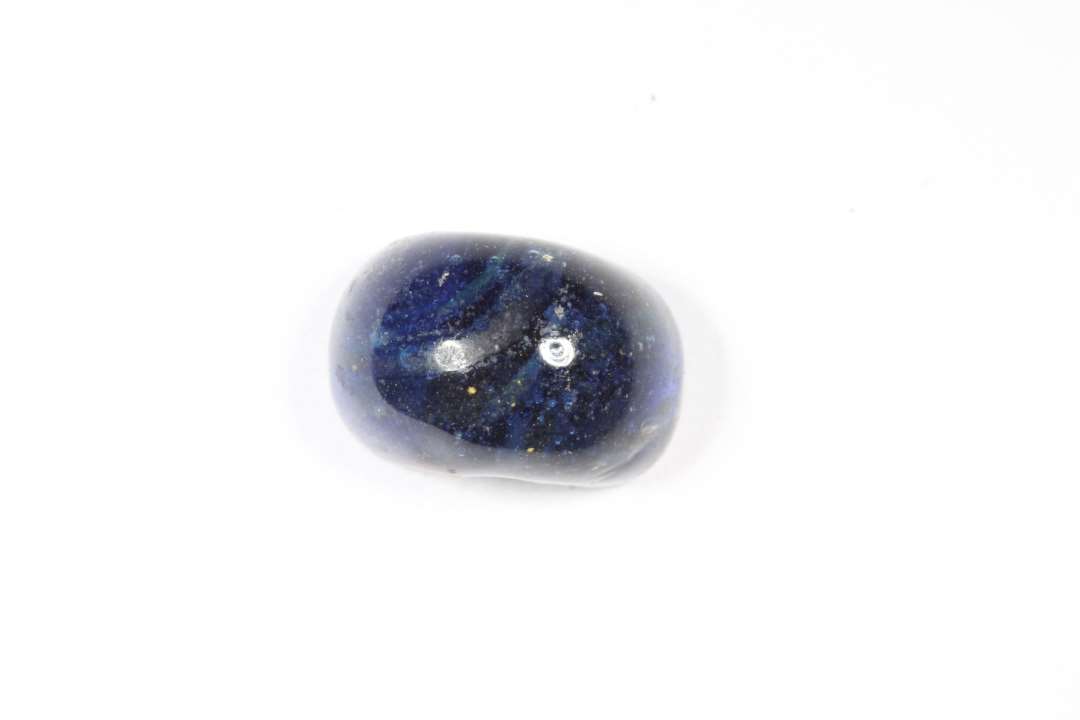 Halv ringformet, gennemsigtig, blå glasperle. Diameter: 1,1 cm.
