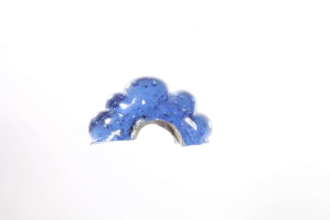 Halv ringformet, melonformet, gennemsigtig, blå glasperle. diameter: 1,1 cm.