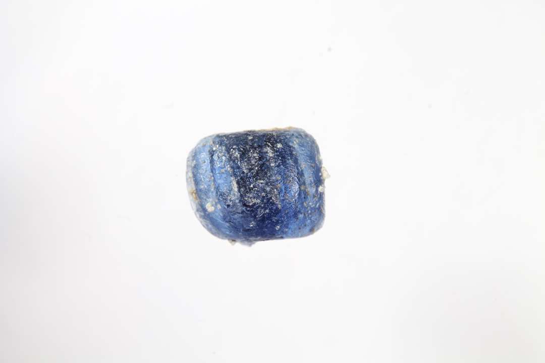 Fragment af ringformet, melonformet, blå glasperle. Diameter: ca 1 cm.