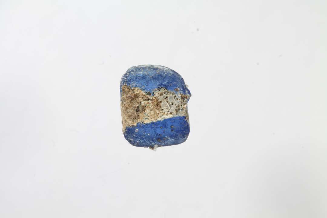 Fragment af ringformet, melonformet, blå glasperle. Diameter: ca 1 cm.