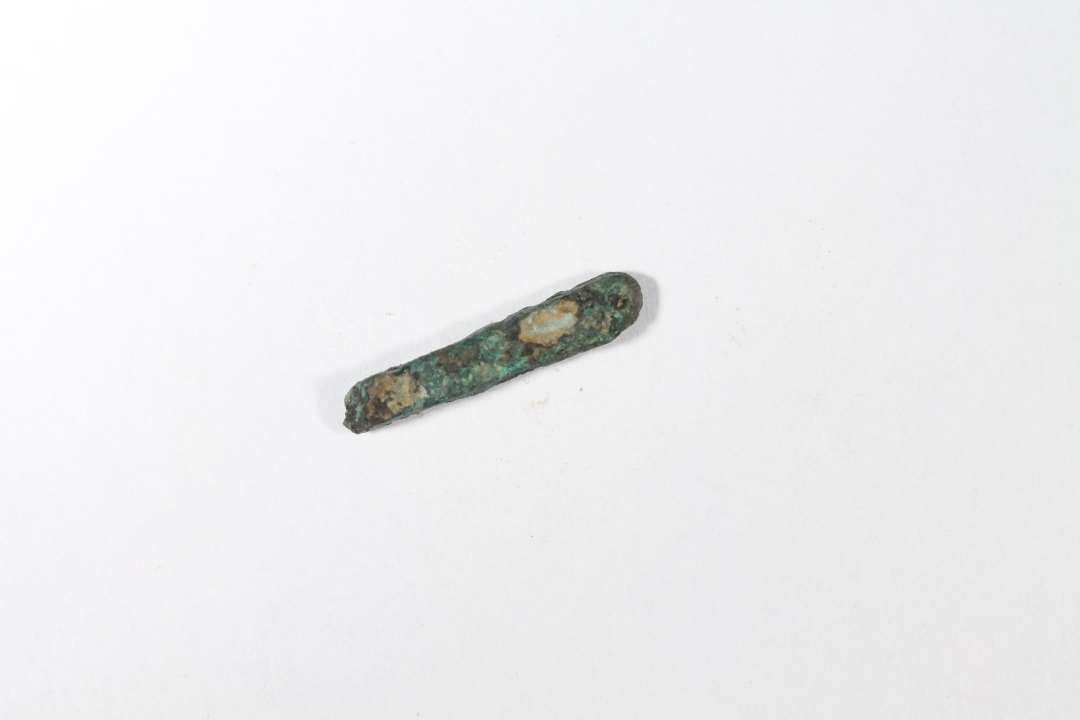 Bronzebarre. Mål: 1,8 x 0,3 x 0,3 cm.

Iflg. metalanalyser hamret kobber (med urenheder)
