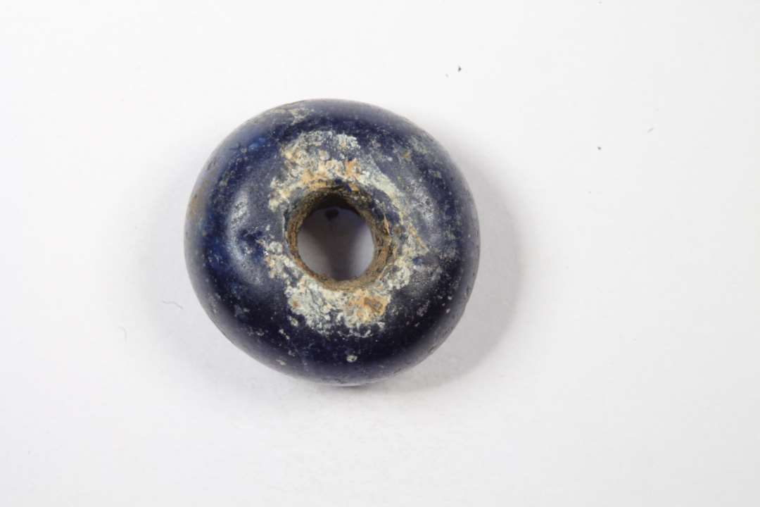 Ringformet, gennemsigtig, blå glasperle. diameter: 1,3 cm.