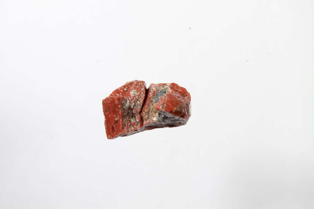 Fragment af cylindrisk uigennemsigtig rød glasperle