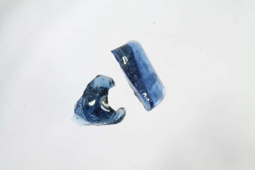 To fragmenter af polyhydride, muligvis polyedriske gennemsigtige blå glasperler