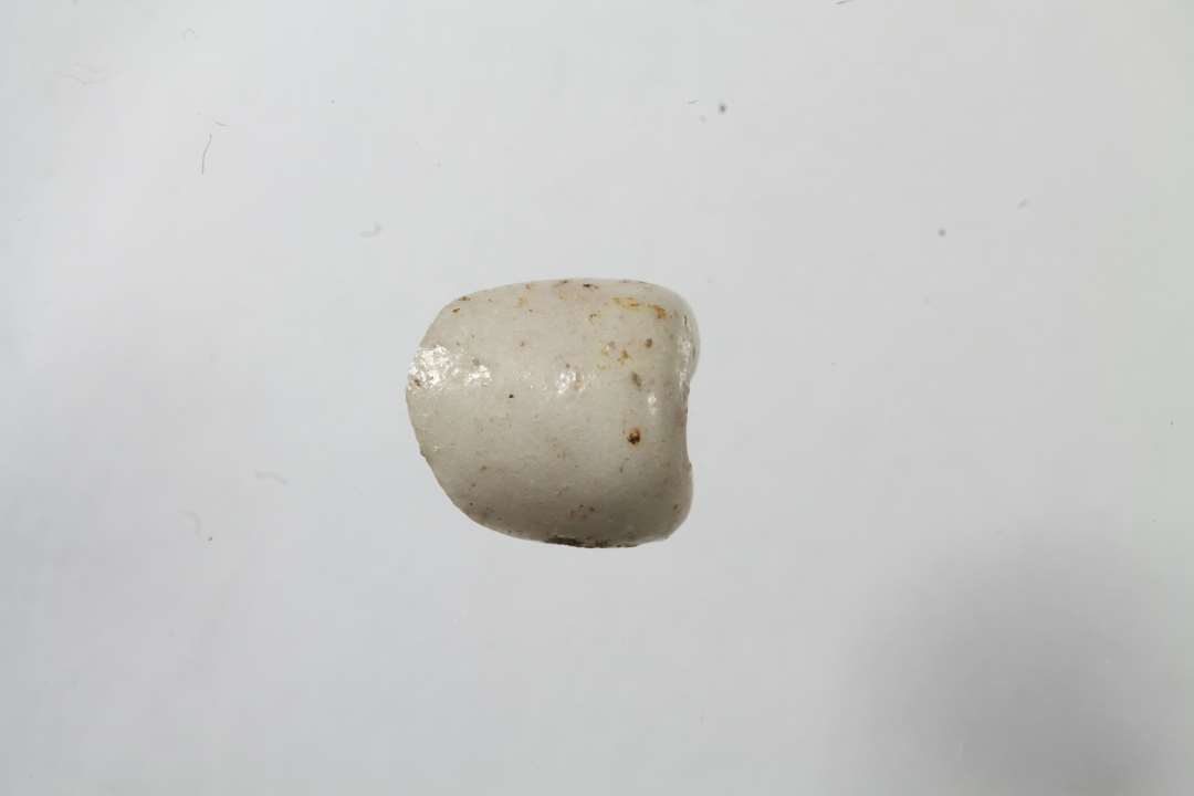 Fragment af cylindrisk, uigennemsigtig, hvidgrå glasperle