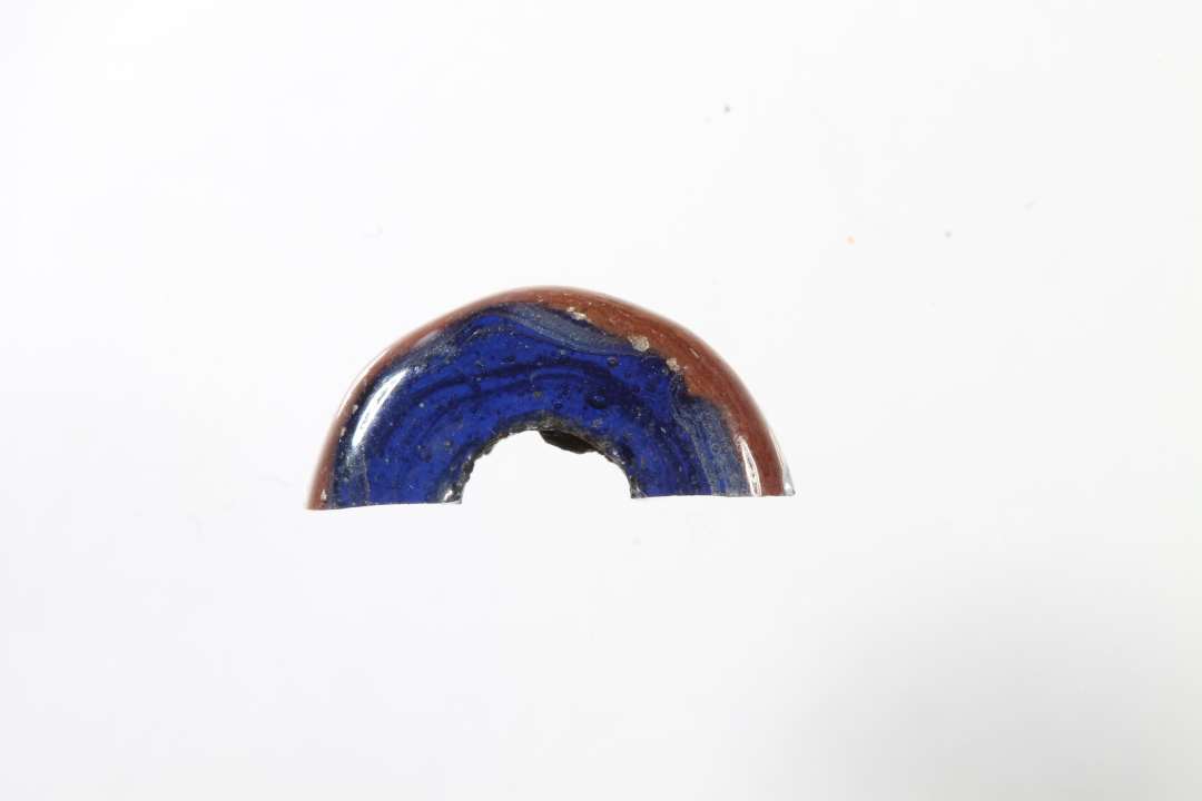 Halv cylindrisk ribeperle, gennemsigtig blå med rødt og hvidt. diameter: 1,2 cm.