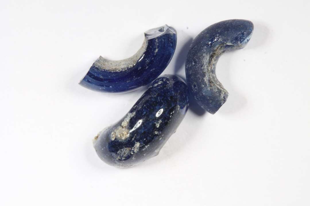 Tre fragmenter af ringformede, gennemsigtige, blå glasperler. diameter: 1,2-1,3 cm.