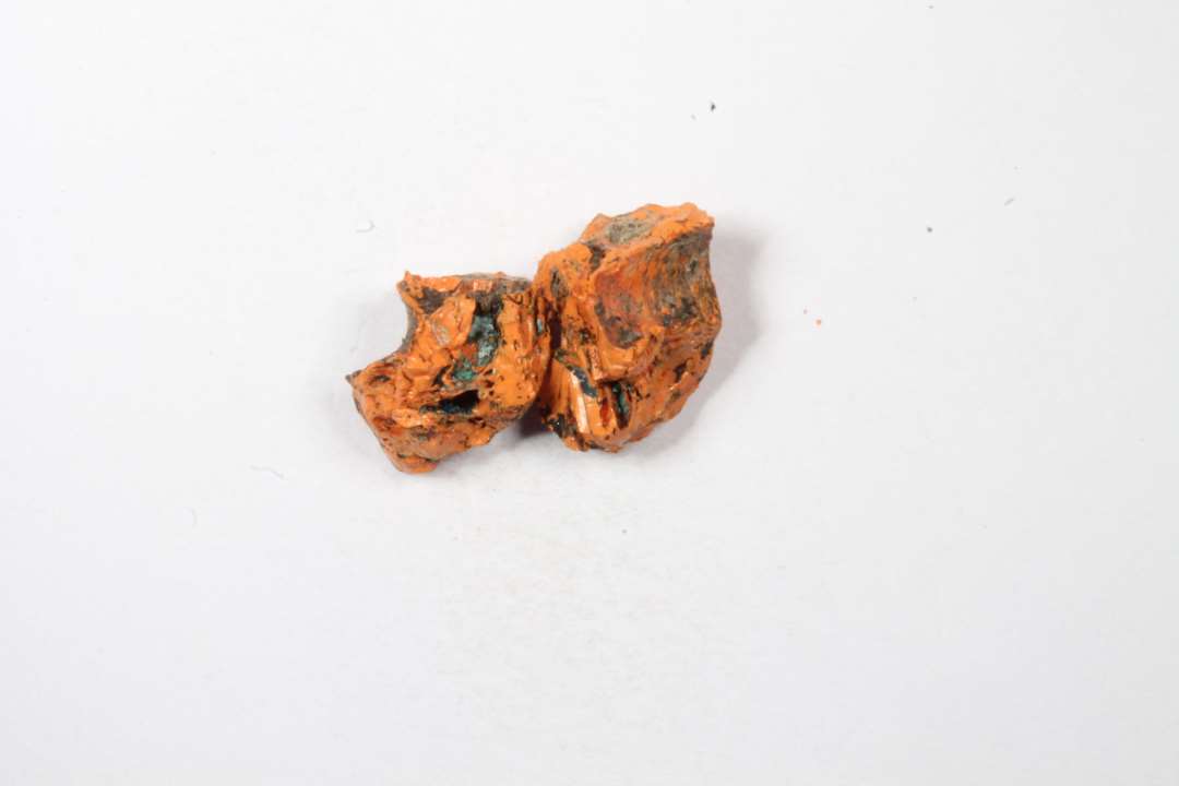 To fragmenter af cylindriske eller tøndeformede uigennemsigtige orange glasperler
