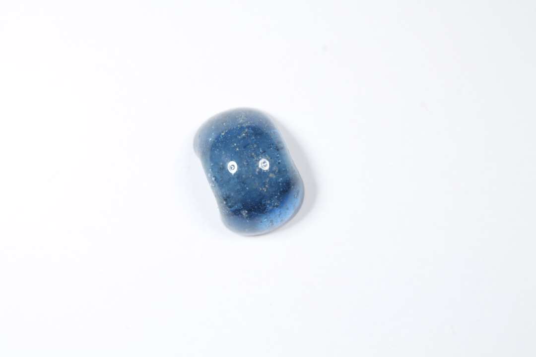 Halv ringformet, gennemsigtig blå glasperle. Diameter: 0,8 cm.