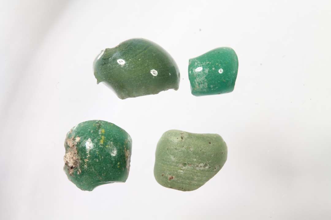 Fire ringformede fragmenter af uigennemsigtige, grønne glasperler