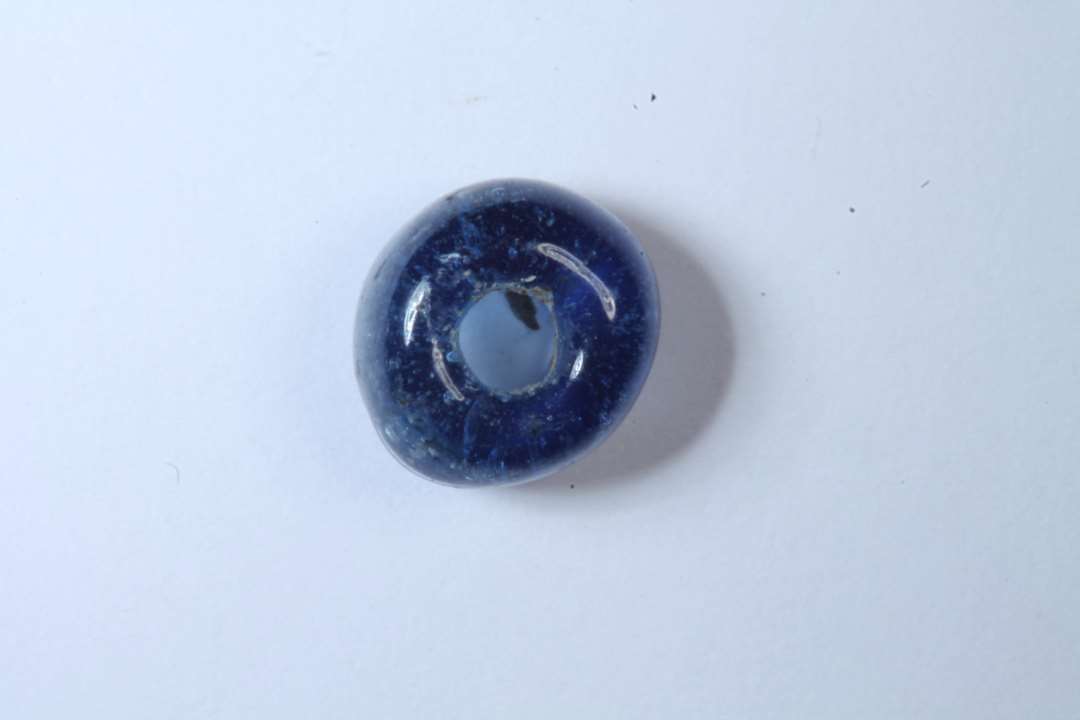 Tøndeformet, hel, gennemsigtig, blå glasperle, diameter: 0,7 cm.