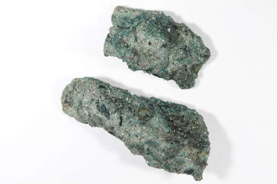 En aflang klump irret bronze. Brækket i to dele. Samlet længde: 6,2 cm.