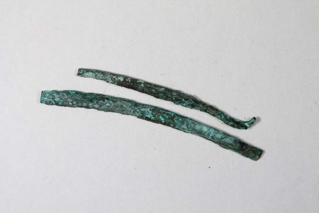To stykker bronzetråd eller nålefragmenter. Længde: 2,5 og 3 cm.