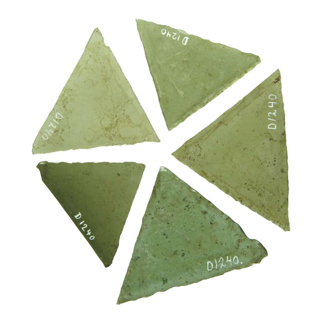 49 hele ruder af klart grønligt glas med afnappede kanter af omtrent ligesidede trekantsform. De fleste af ruderne er ikke strengt ligesidede, idet trekantens grundlinie i regelen er noget længere end de to andre trekantsider. Størrelsen varierer fra en trekantside længde på ca. 3,5 cm. til ca. 7 cm. Omkring halvdelen af ruderne har en sidelængde på ca. 5 cm. medens 5 - 6 stykker er mindre, resten har en sidelængde mellem 5 - 7 cm. To af ruderne adskiller sig ved, at deres hjørner ved grundlinien er afnappede i en bredde af ca. 1,5 cm. Desuden tre kasser fyldt med diverse grønlige og blålige skår af rudeglas. Ialt ca 850 skår til D1240.