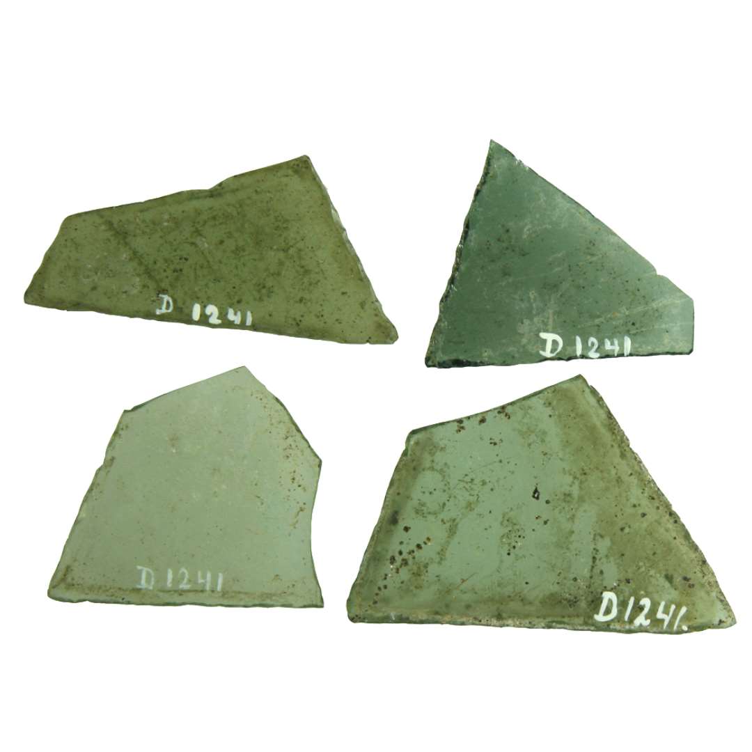 119 rudefragmenter af klart grønligt glas med afnappede kanter af omtrent ligesidede trekantsformer. De fleste af ruderne er dog ikke strengt ligesidede, idet trekantens grundlinie i reglen er noget længere end de to andre trekantsider. Størrelsen varierer en del fra en sidelængde på ca. 4,5 cm. til ca. 7,5 cm. Langt den overvejende del af ruderne har med en mellem 6 og 7 cm., medens ruder med en sidelængde på omkring 5 - 5,5 cm. kun udgør en halv snes stykker. 
