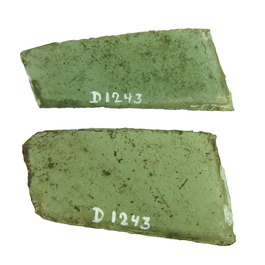 To hele ruder af klart, grønligt glas med afnappede kanter af skæv og uregelmæssig rhombeform. Langsiderne på begge ruder ca. 7,5 cm., kortsidelængden fra 2,2 til 4,2 cm.