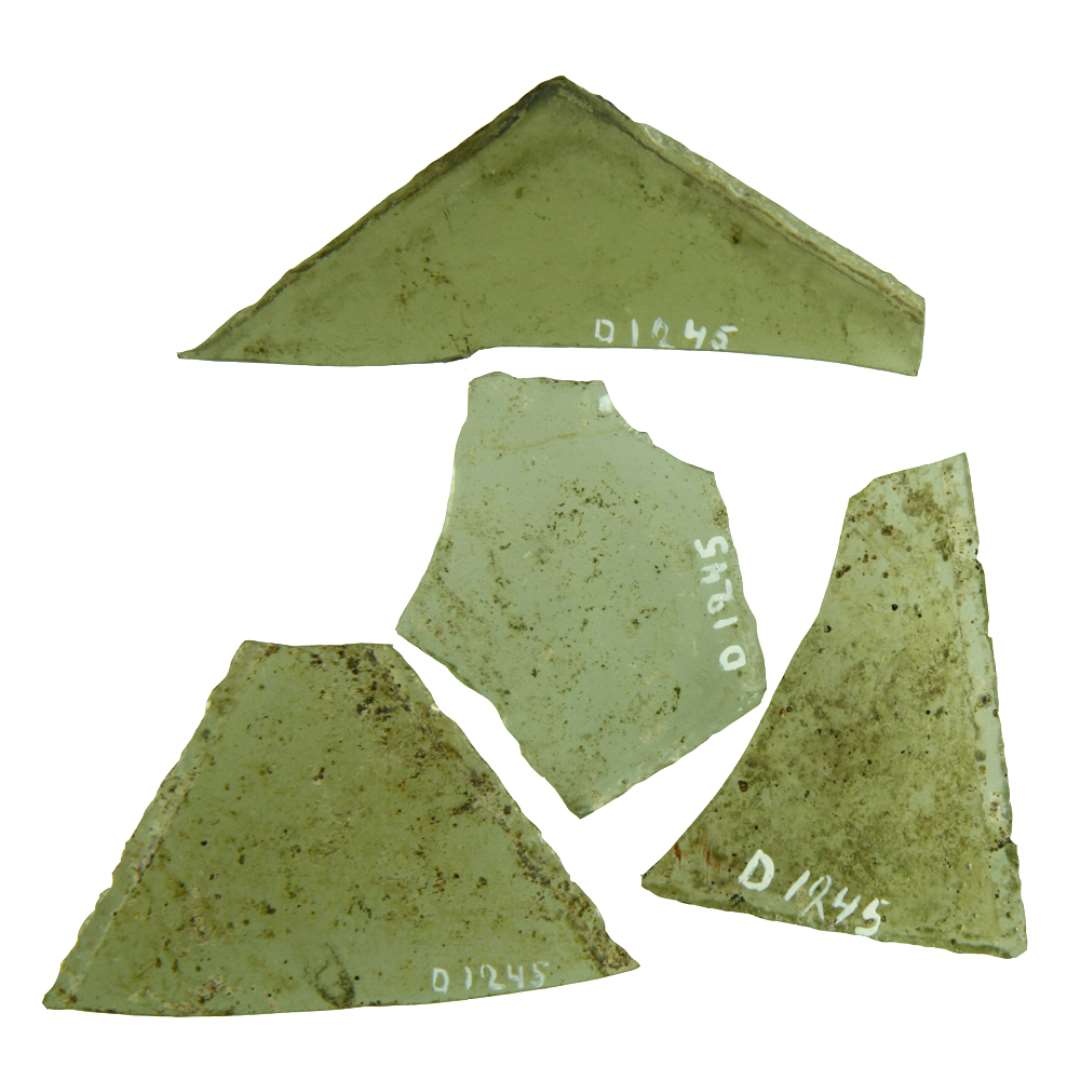 154 fragmenter af klart grønligt glas med afnappede kanter antagelig hidrørende fra ruder af trekant- eller rhombeform. Ruderne kendetegnes ved et spidsvinklet eller stumpvinklet hjørne.