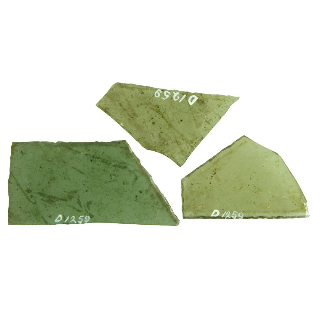 14 rudefragmenter af klart, grønligt glas med afnappede kanter. Fragmenterne udviser kun en bevaret side, der mødes med de delvis afbrudte tilstødende sider i en ret og en stump vinkel. Et af fragmenterne er fremstillet af en ca. 5,5 mm tyk glasskive.