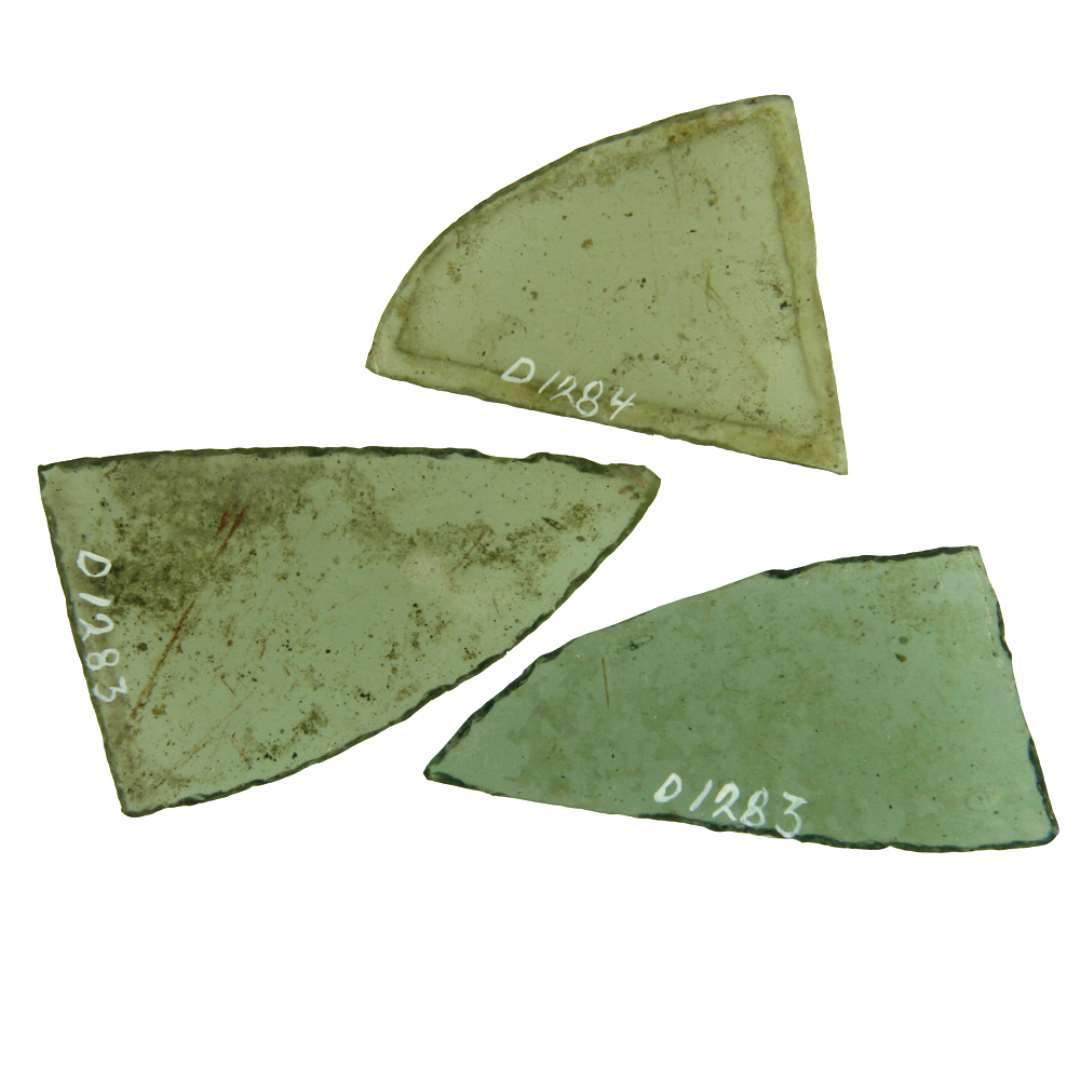 3 hele ruder af klart grønligt glas med afnappede kanter. Form af spidsvinklede trekanter, hvis længste side danner en jævn udadbuet krumning. Største mål henholdsvis: 3,75 x 5 cm. 3,2 x 6,4 cm. 3,75 x 6,4 cm.