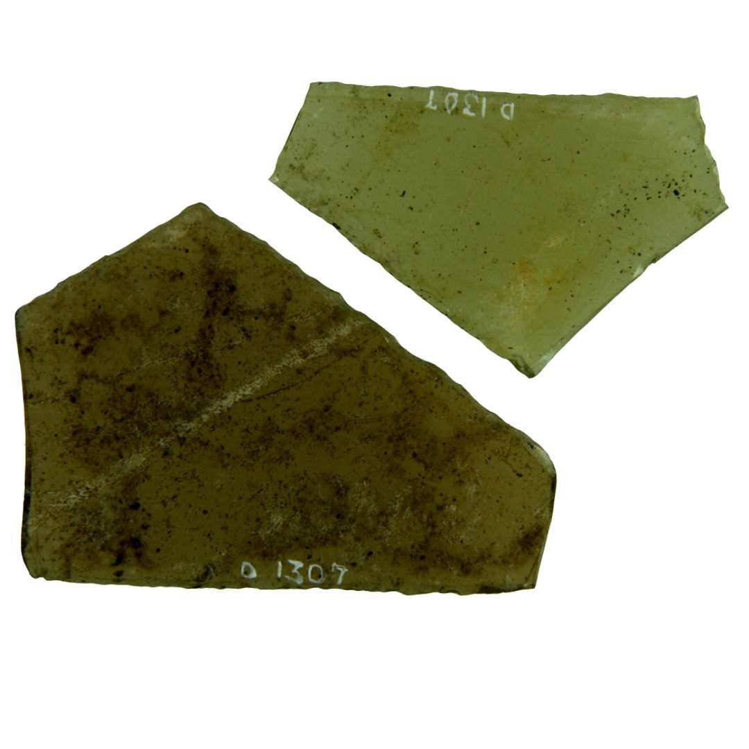 2 rudefragmenter af gulligt glas med afnappede kanter fra ruder af form som spidsvinklede, ligebenede trekanter med de spidsvinklede hjørner afbrudt. Største længde og højde: 5,4 x 4,2 cm. 6,9 x 5,0 cm.
