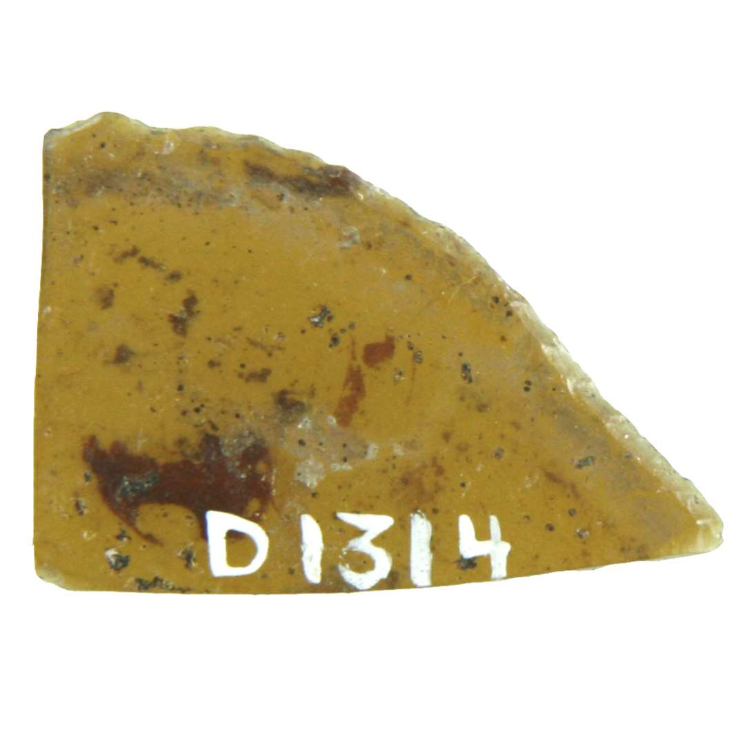 1 rudefragment af gult glas med et stykke af en afnappet, svagt konveks yderkant bevaret. Største mål 2 x 2,9 cm.