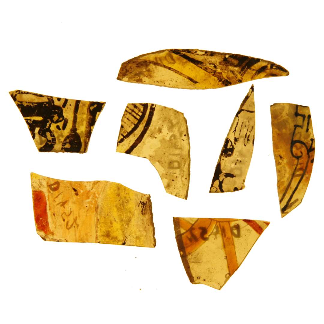 161 fragmenter fra ruder af grønlig glas med afnappede kanter bemalet fortrinsvis med brune farver med varierende mønstre i streg og/eller geometrisk form. Største mål ca.: 2-6 cm.