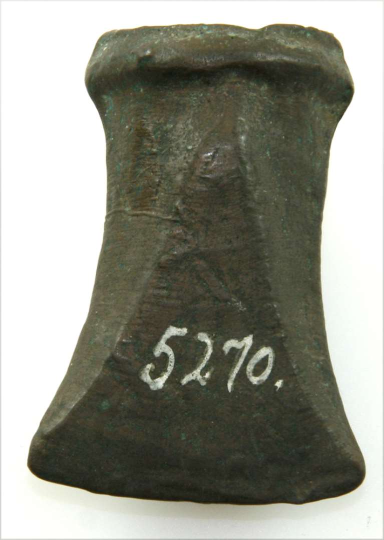 Bronzecelt, 6 Cm. lang og 4¼ Cm. bred. Spids ovalagtig Skaftaabning med en kraftig Kant uden Øsken. Indvendig Støbesømme paa Bredsiderne.