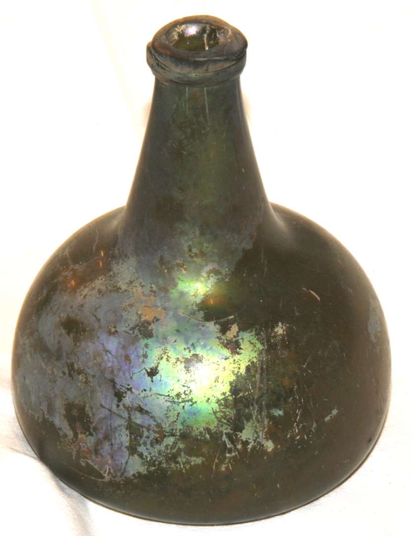 Glasflaske, karaffelformet, med rundet underdel og kort hals. Højde: 15 cm., bundbredde: 12 cm.
