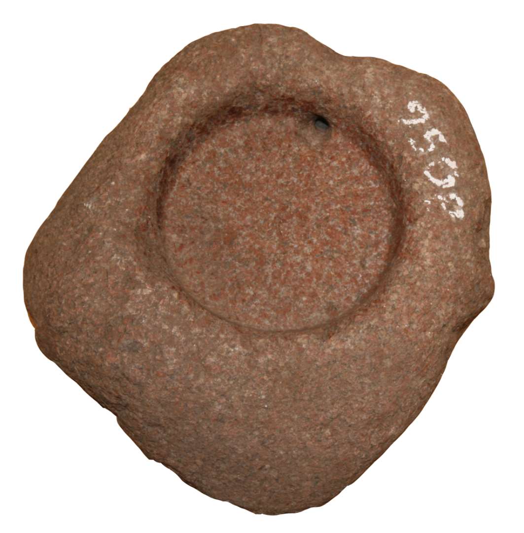 Kværnsten, underligger. Af granit. Med cirkulær fordybning til overligger med udhuggede, radiære riller og afløbshul. Stenens største mål: ca. 40 cm., fordybningens diameter: ca. 18 cm. 