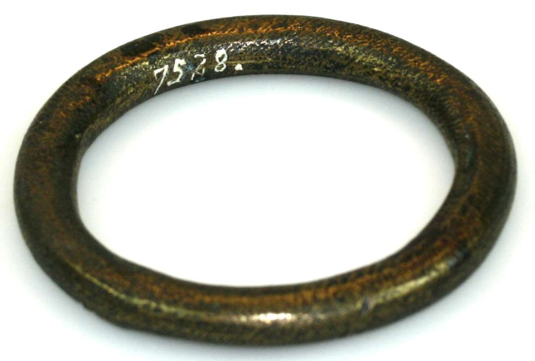 Bronzering, formodentlig fra seletøj. På den ene side ornamenteret med cirkelslag og skråstreger. Diameter: 7,5 cm.