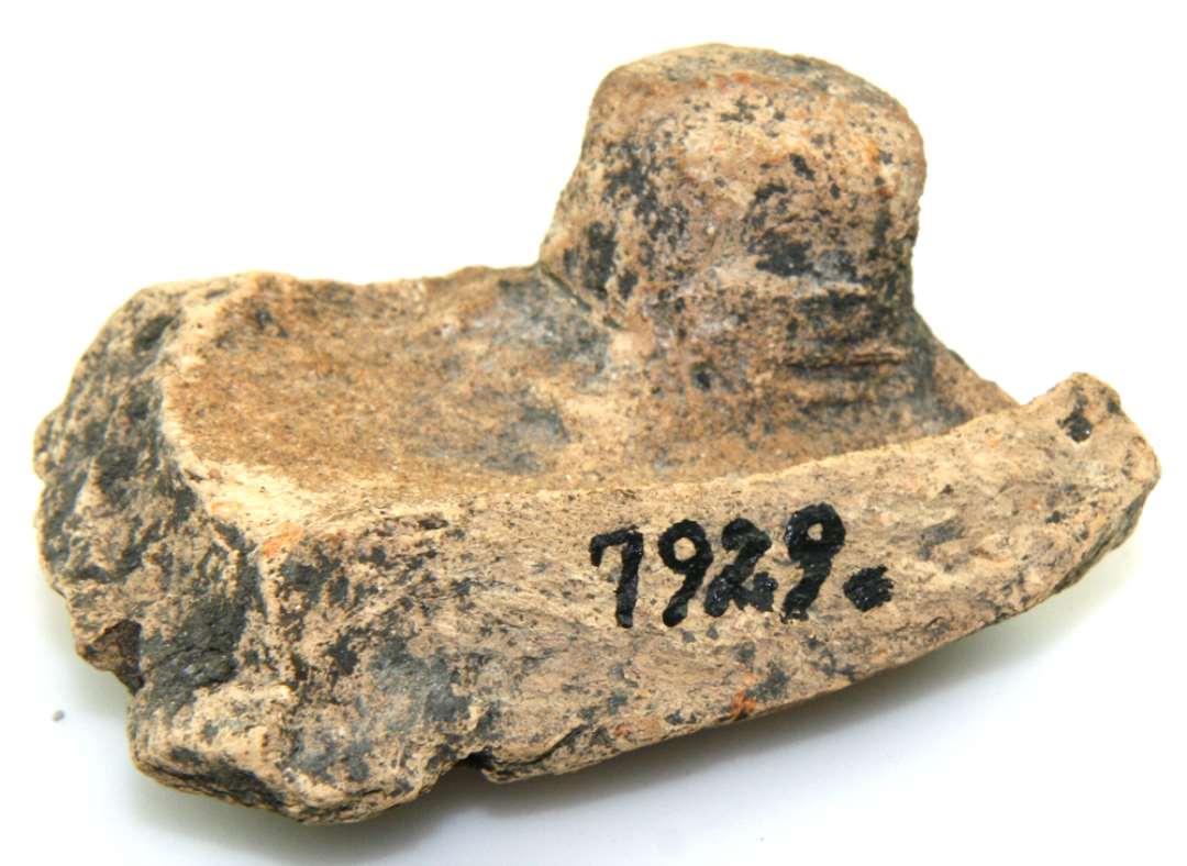 Fragment af tagsten, en munk. Mål: 7,2 x 5,3 cm.