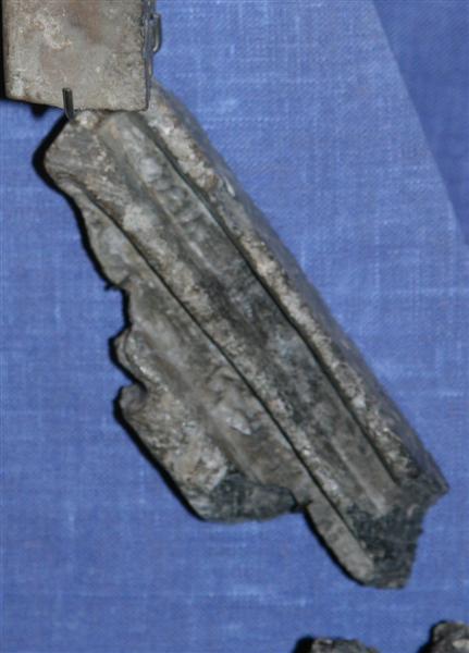 Fragment af fin sandstensform til støbning af blysprodser til vinduesruder. Mål: længde 12 cm., bredde 4 cm.