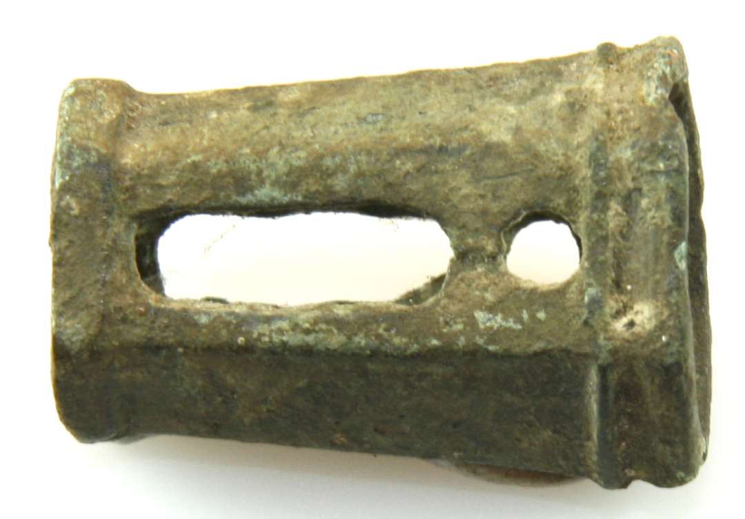 Lysepibe af bronze, sekskantet, gennembrudt i de to sider. Længde 3,6 cm., diameter 2-2,6 cm.