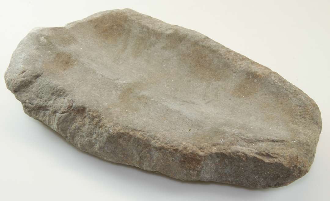 Slibesten af sandsten; hulslidt på de to brede sider. Mål: 37 x 16 x 6 cm.