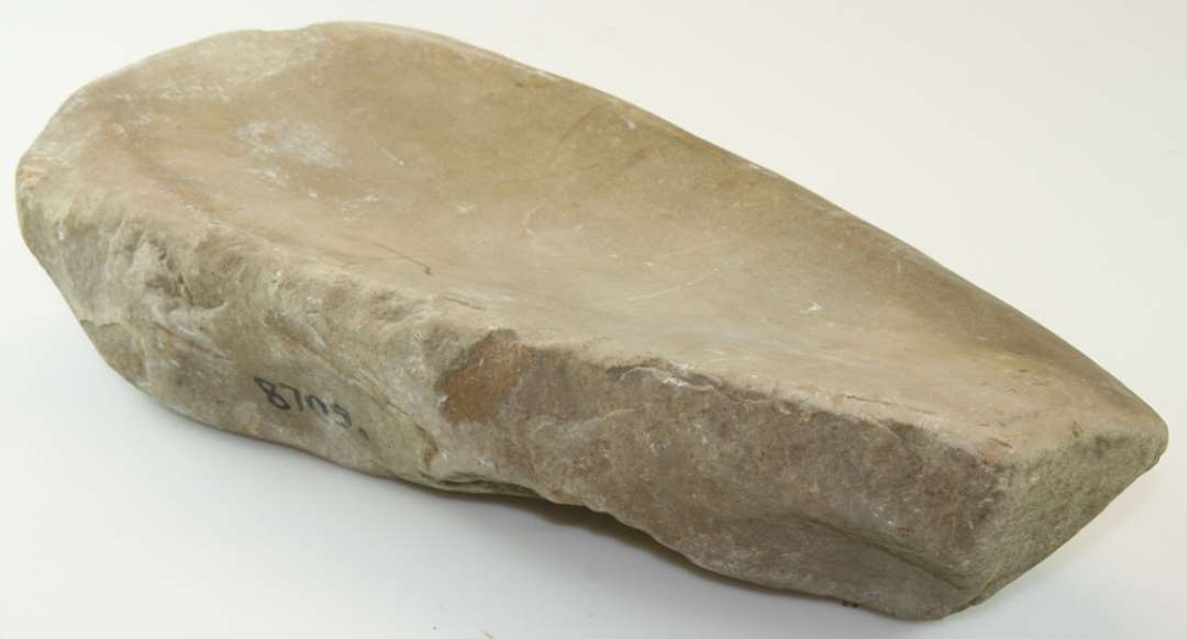 Slibesten af granit, hulslidt på de to brede sider. Mål: 37 x 18 x 8,5cm.