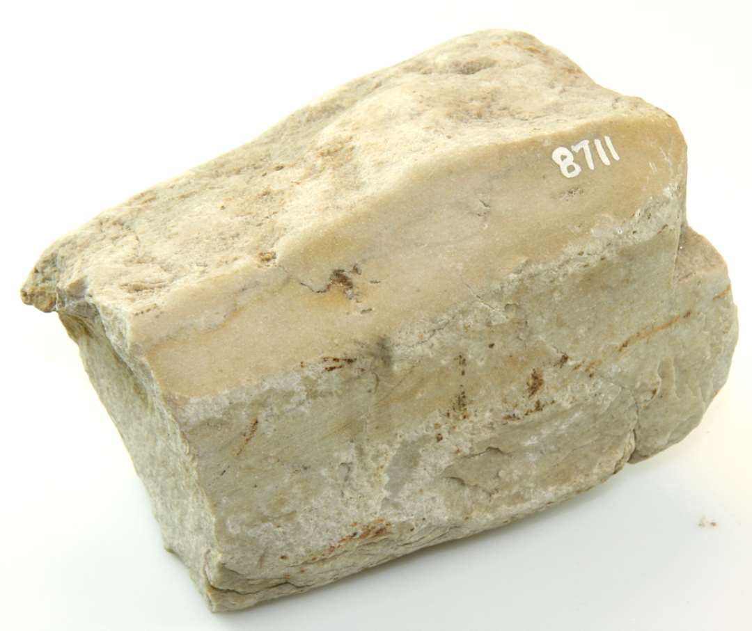 Fragment af slibesten af granit, slidt på kanter og flader. Mål: 14 x 10 x 10 cm.