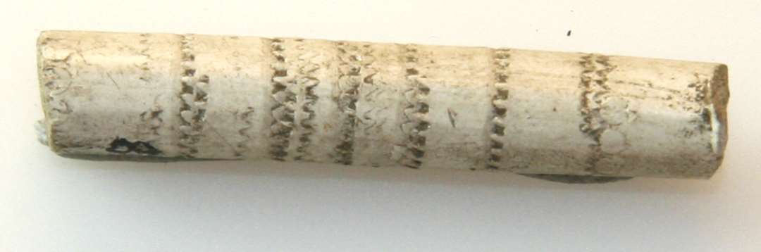 Fragment af kridtpiberør. Med omløbende, indstemplet ornament. Længde: 4 cm.