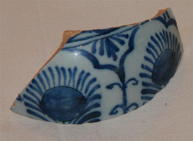 1 skulderskår fra kraftig rundbuget krukke af blådekoreret fajance med stiliseret blomstermotiv i arkadeindraming.